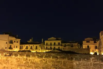 a group of buildings at night behind a wall at Ai Carrettieri della Cattedrale in Palermo