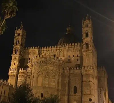 a large building with a clock tower at night at Ai Carrettieri della Cattedrale in Palermo