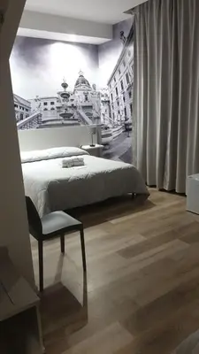 a bedroom with a large bed and a chair at Due Passi Suite in Palermo
