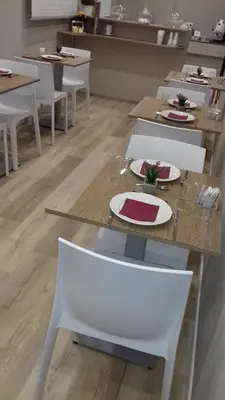 a dining room with white tables and white chairs at Due Passi Suite in Palermo