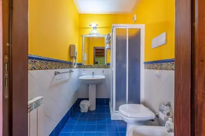 a bathroom with a sink and a toilet and a mirror at Stenopus Greco Casa per AFFITTI TURISTICI in Santa Flavia
