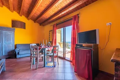 a dining room with a table and a television at Stenopus Greco Casa per AFFITTI TURISTICI in Santa Flavia
