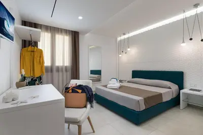 a bedroom with a bed and a desk in a room at B&B Acqua Azzurra in San Vito lo Capo