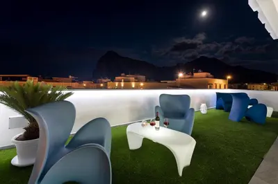 a patio with chairs and a table at night at B&B Acqua Azzurra in San Vito lo Capo