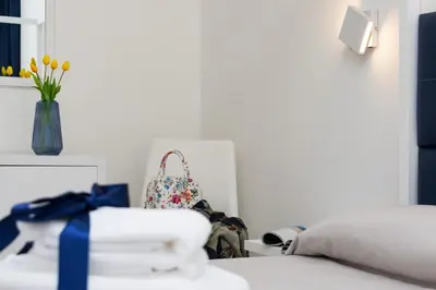 a bedroom with a bed and a bag and flowers at B&B Acqua Azzurra in San Vito lo Capo