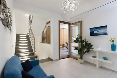 a living room with a blue couch and a staircase at B&B Acqua Azzurra in San Vito lo Capo