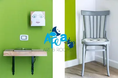 a chair and a desk in a room with a green wall at Afea Art & Rooms in Palermo