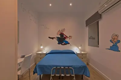 a bedroom with a bed with a blue blanket on it at Afea Art & Rooms in Palermo