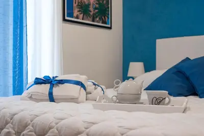 a bed with towels and a tray with a tea set on it at Kasavucciria Apartments in Palermo