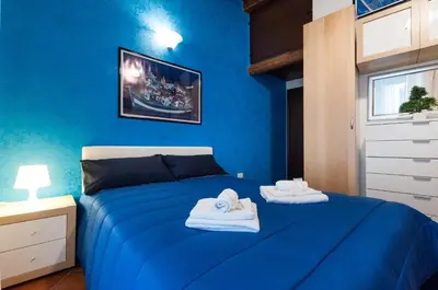 a blue bedroom with towels on a bed at Kasavucciria Apartments in Palermo