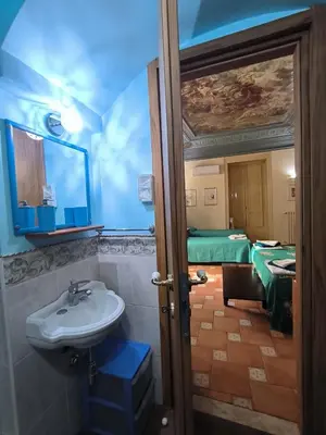 a bedroom with a blue bed with two lamps at Vittorio Emanuele Rooms di Prinzi in Palermo