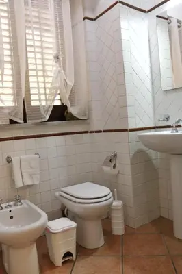 a white bathroom with a toilet and a sink at Casa Palazzo Reale in Palermo