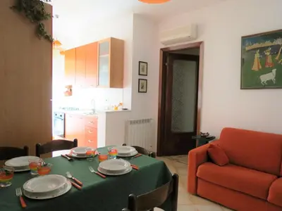 a living room with a table and a red couch at Appartamento Libertà in Palermo
