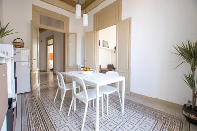 a white dining room with a white table and chairs at Aria Rooms in Palermo