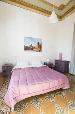 a large pink bed in a white room at Aria Rooms in Palermo