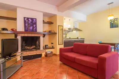 a living room with a red couch and a fireplace at Casa Ibiscus x2 in Palermo