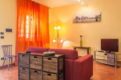a living room with a red couch and a television at Casa Ibiscus x2 in Palermo