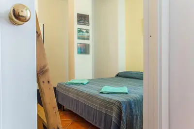 a small bedroom with a bed with two towels on it at Casa Ibiscus x2 in Palermo