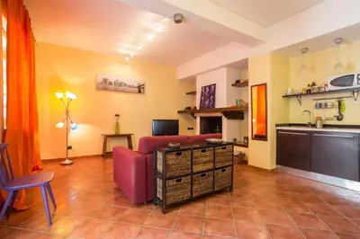 a living room with a red couch and a kitchen at Casa Ibiscus x2 in Palermo