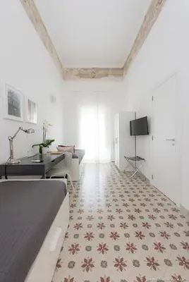 a bedroom with a bed and a desk and a television at Dimora CentroWell in Palermo