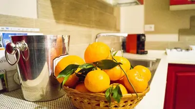 a basket of oranges on a counter next to a juicer at Le Case di Ninni in Palermo