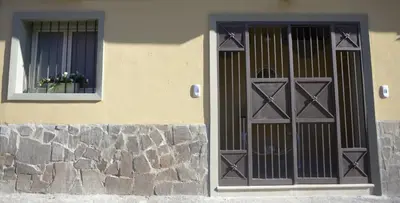 a building with a door and a window with flowers at Le Case di Ninni in Palermo