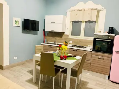 a kitchen with a white table and chairs in a kitchen at Le Case di Ninni in Palermo