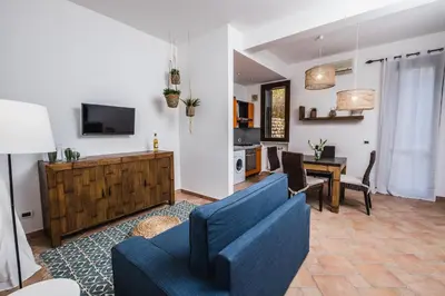 a living room with a blue couch and a table at LuminHouse Mondello Arancia in Mondello