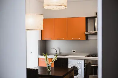 a kitchen with orange cabinets and a wooden table at LuminHouse Mondello Arancia in Mondello