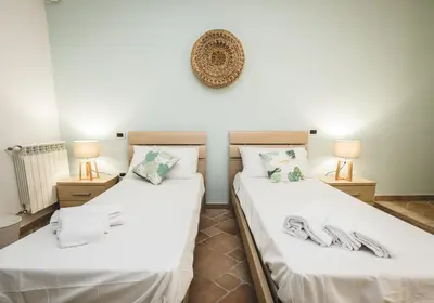 two beds in a room with two lamps at LuminHouse Mondello Fico in Mondello