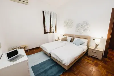 a bedroom with two beds and a laptop on a desk at LuminHouse Mondello Zibibbo in Mondello