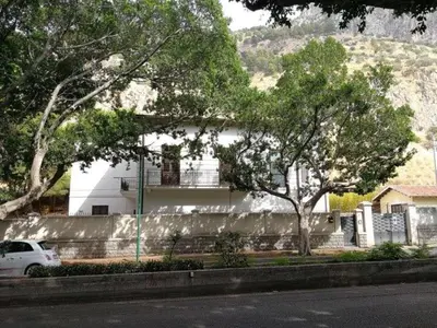 a white car parked in front of a white house at LuminHouse Mondello Zibibbo in Mondello