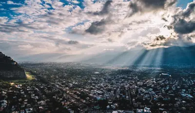 a view of a city with the sun shining from a mountain at LuminHouse Mondello Limone in Mondello