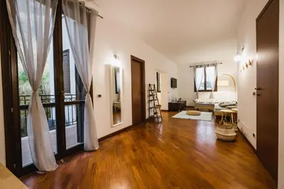 a living room with wooden floors and a large window at LuminHouse Mondello Limone in Mondello