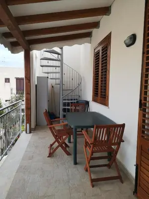 a patio with a table and chairs on a balcony at Casa Frida in San Vito lo Capo