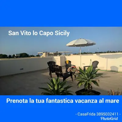 a patio with two chairs and an umbrella at Casa Frida in San Vito lo Capo