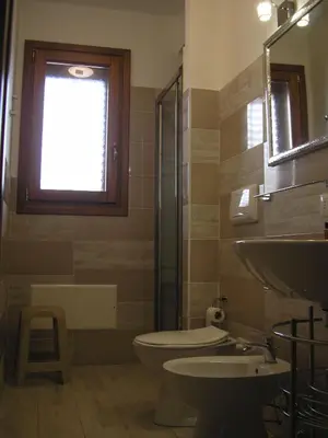 a bathroom with a toilet and a sink and a window at Casa Frida in San Vito lo Capo