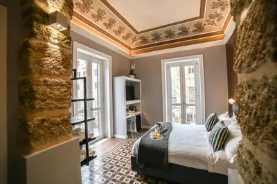 a bedroom with a bed and two windows and a ceiling at Family Affair Luxury Rooms&Suites in Palermo