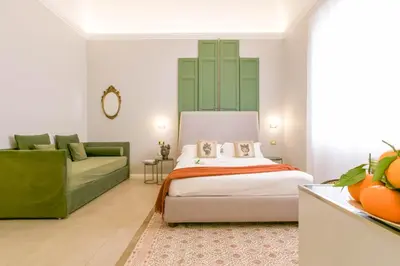 a bedroom with a bed and a couch at Family Affair Luxury Rooms&Suites in Palermo