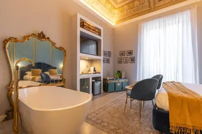 a bathroom with a tub and a bed and a bedroom at Family Affair Luxury Rooms&Suites in Palermo