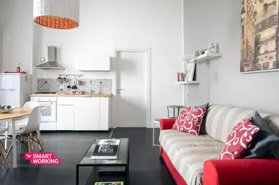 a living room with a red couch and a kitchen at APT Ballarò House - Superior Apartment in Palermo