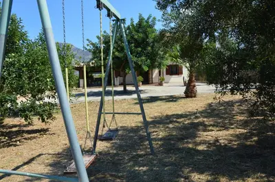 an empty swing set in a park with trees at Casa vacanza Borgo Parrini in Partinico