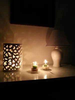 two candles are sitting on a table with a lamp at Casa dolce Casa in Sambuca di Sicilia