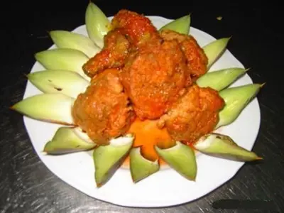 a white plate with food on top of apple slices at Agriturismo La Targa in Buonfornello