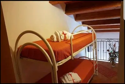 a bunk bed in a room with an orange blanket at Casa Vacanza Brigida in Scopello