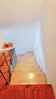 a staircase with wooden floors and a white wall at Casa Vacanza Brigida in Scopello