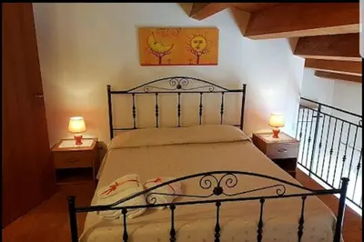 a bedroom with a bed with two lamps on two tables at Casa Vacanza Brigida in Scopello