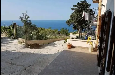 an empty street with the ocean in the background at Casa Vacanza Brigida in Scopello