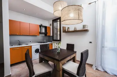 a kitchen with a table and chairs and a sink at LuminHouse Villa Mondello in Mondello