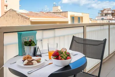 a table with food and a bowl of fruit on a balcony at Ciccio Rooms and breakfast - Self check-in in Palermo